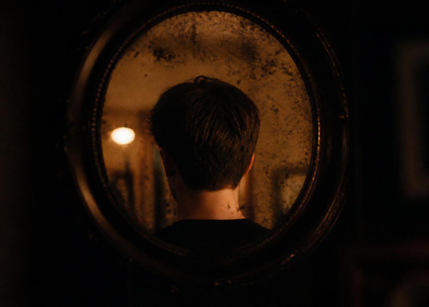 The back of a freshly cut head reflected in a spotted mirror