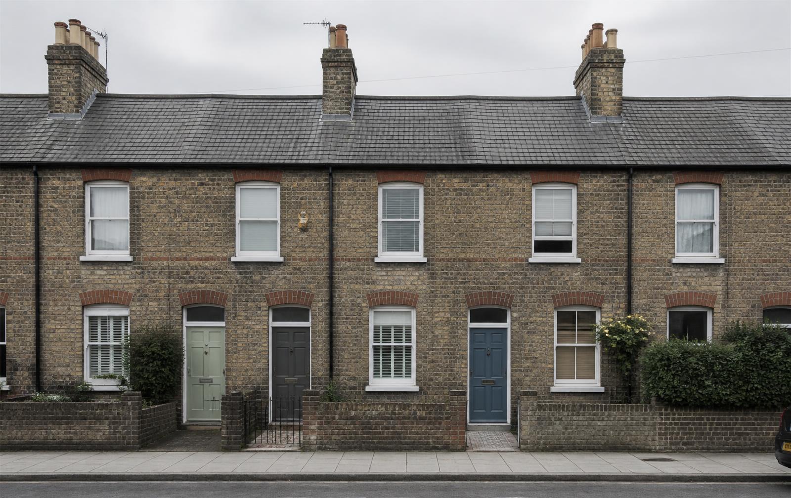 A residential street of brick houses in low afternoon light